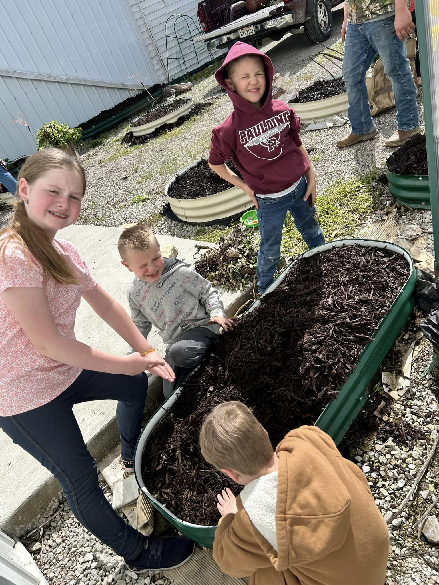 Group of children working together in a raised garden bed