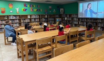 Hinojosa Elementary International Dot Day group of children watching a presentation in a school library
